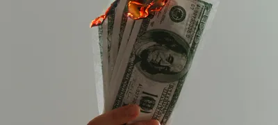 Billetes ardiendo representando el presupuesto publicitario malgastado por errores de tracking en Google Ads